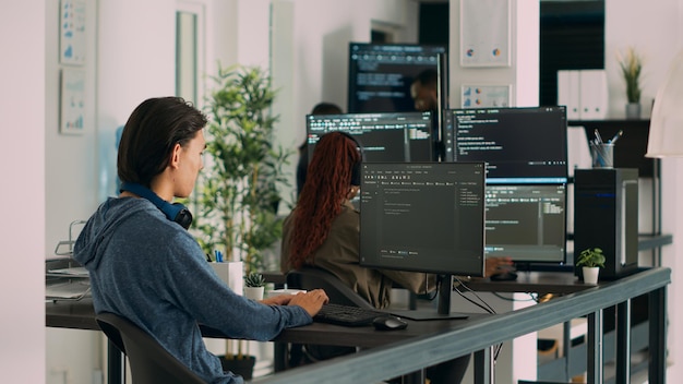 Azjatycki programista piszący kod na komputerze, wyświetlający algorytm sztucznej inteligencji. Program bazy danych kodujący programistów aplikacji, wykonujący przetwarzanie w chmurze za pomocą tego serwera. Strzał ze statywu.
