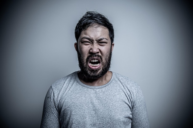 Azjatycki przystojny mężczyzna zły na białym tle Portret młodej koncepcji męskiej stresu