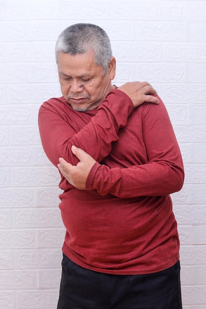 Azjatycki starszy mężczyzna z bólem ramienia i zwichnięciem więzadła w sportowym zapaleniu i urazie