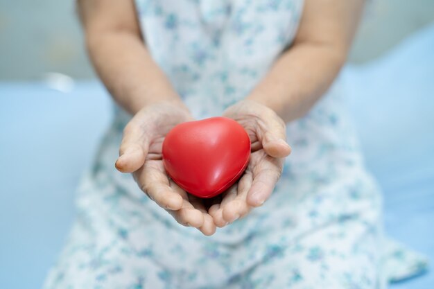 Azjatycki starszy pacjent gospodarstwa czerwone serce.