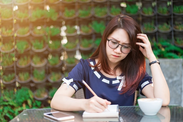 Azjatycki szczęśliwy młody biznesowej kobiety działanie robi notatce coś robi notatkom w lecie p