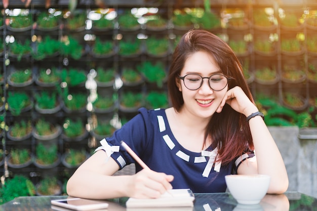 Azjatycki szczęśliwy młody biznesowej kobiety działanie robi notatce coś robi notatkom w lecie p