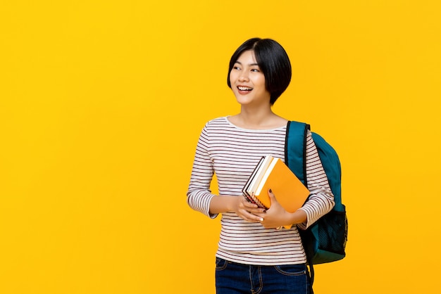 Azjatycki żeński student collegu z plecaka mienia książkami