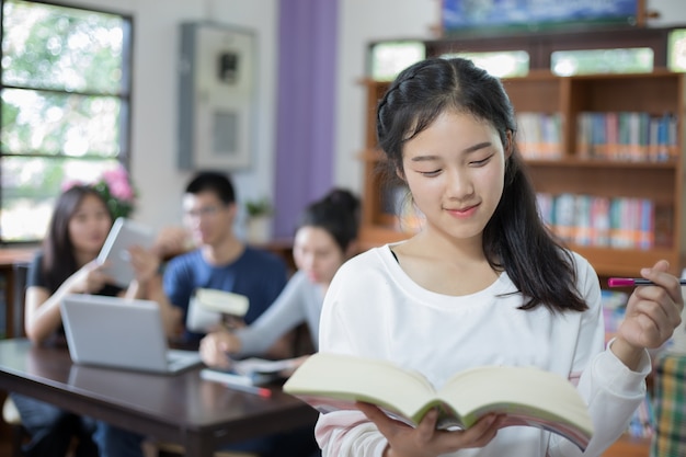 Azjatyckich kobiet studentów gospodarstwa do wyboru Book in library