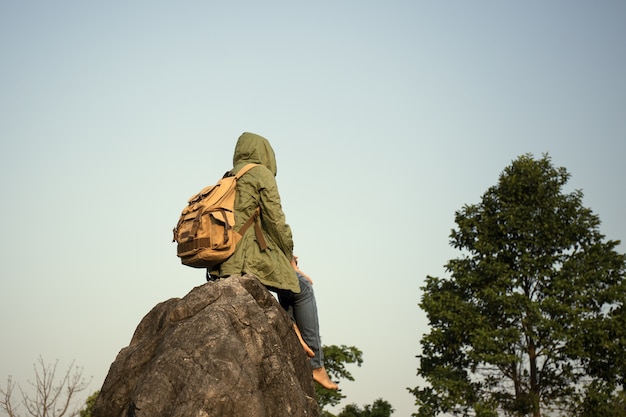 Azjatyckich kobiet turystyczni backpackers siedzi naturę i cieszy się