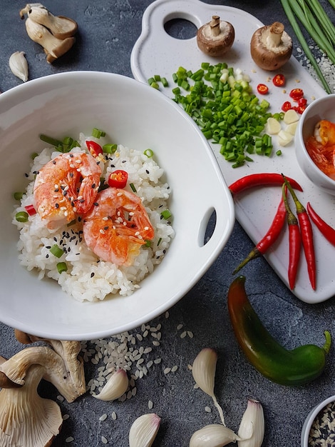 Azjatyckie jedzenie na ciemnym tle, Ryż wok z krewetkami i grzybami, W trakcie przygotowania, Zbliżenie pionowe, Selektywne ustawianie ostrości