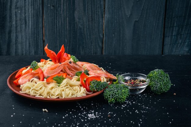 Azjatyckie jedzenie z owocami morza i warzywami Krewetki Brokuły Papryka Przyprawy Widok z góry Wolne miejsce na tekst
