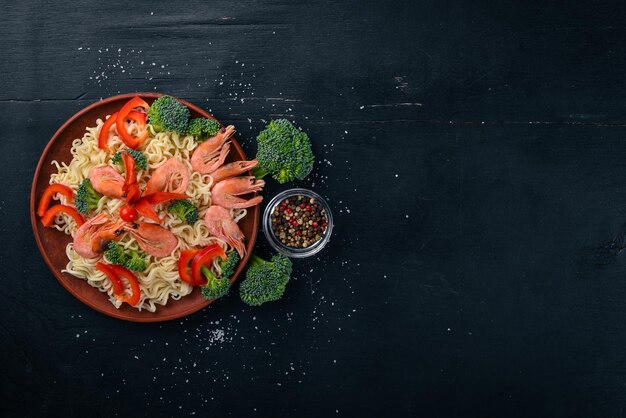 Azjatyckie jedzenie z owocami morza i warzywami Krewetki Brokuły Papryka Przyprawy Widok z góry Wolne miejsce na tekst