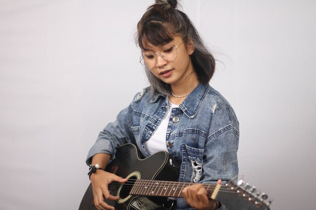 Azjatyckie kobiety grające na gitarze na białym tle