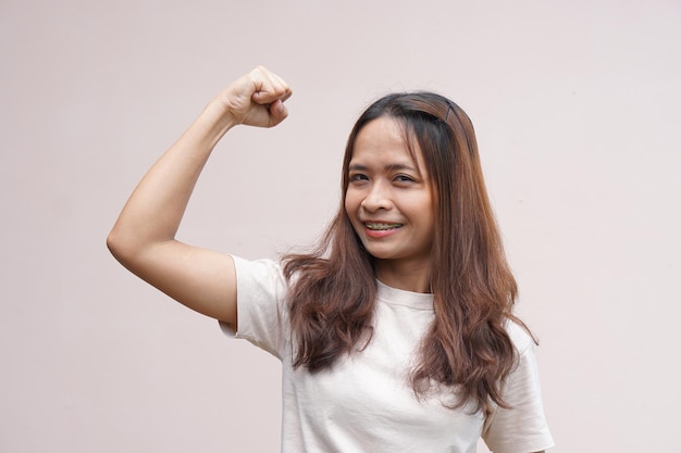 Azjatyckie kobiety napinają mięśnie i pokazują swoją siłę.