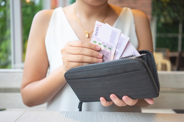 Azjatyckie Kobiety Pobierają Z Torebki Tajskie Banknoty, Aby Zapłacić Za Jedzenie Lub Zapłacić Za Usługi.