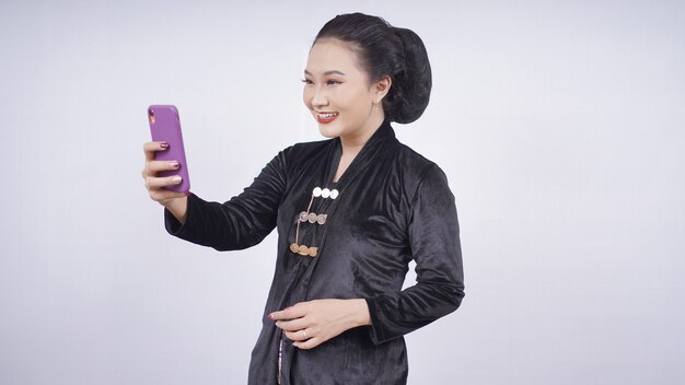 Azjatyckie Piękności W Kebaya Bawiące Się Telefonem Komórkowym Na Białym Tle