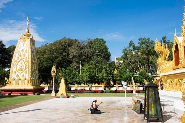 Azjatyckie tajskie kobiety szanują modlący się posąg Buddy i chedi w Wat Phra That Nong Bua w Ubon Ratchathani Tajlandia