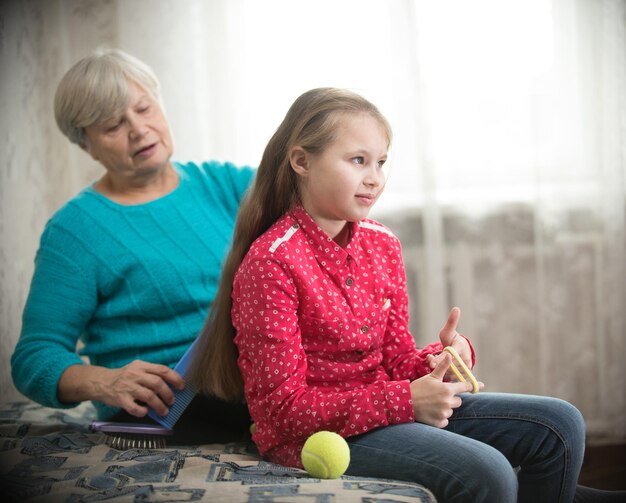 Babcia czesze długie włosy swojej wnuczce