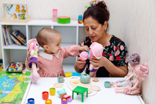 Babcia i maluch bawią się zabawkami w domu