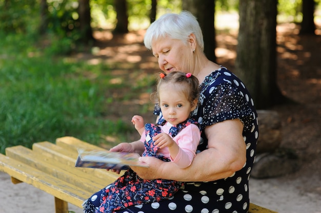 Babcia i wnuczka czytają książkę w parku