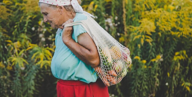 Babcia nosi warzywa w torbie na zakupy Selektywne skupienie