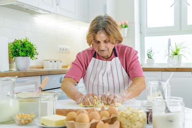 Babcia stara kobieta w kuchni piecze ciasto w kuchni Selektywne skupienie Jedzenie