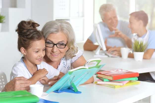 Babcia z uroczą małą dziewczynką odrabiają razem pracę domową