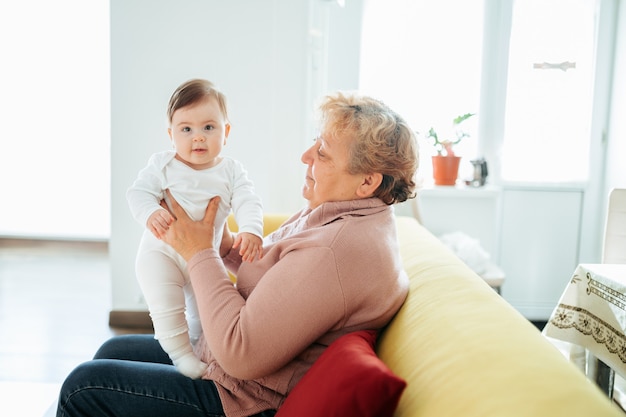 Babcia ze swoją uroczą wnuczką dziecko uśmiechnięta rozmowa gra szczęśliwa zrelaksowana starsza dorosła babcia...