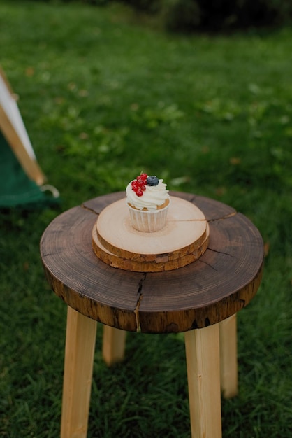 Babeczka z jagodami na drewnianym stole w letnim parku