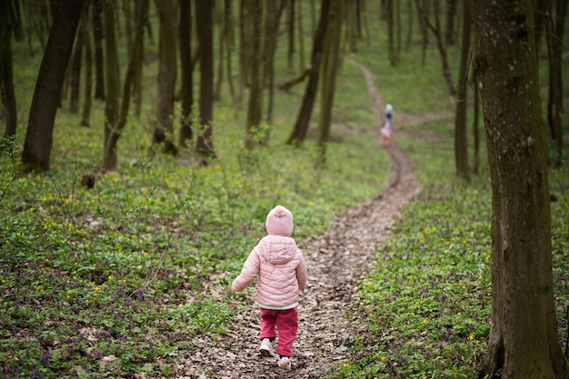 Back of running kids na ścieżce leśnej wiosny Szczęśliwe chwile z dzieciństwa