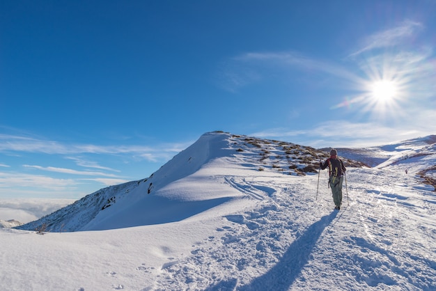 Backpacker kobieta trekking na śniegu w Alpach.