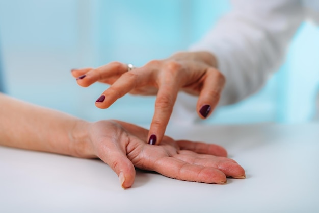 Badanie dłoni starszego pacjenta z zespołem cieśni nadgarstka Zbliżenie obrazu nadgarstka starszej kobiety