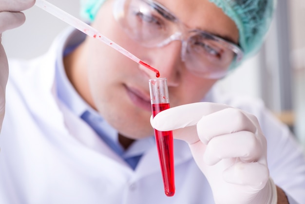 Zdjęcie badanie krwi w laboratorium z młodym naukowcem