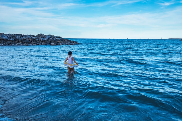 Bądź silny. Chłopiec Stojący pośrodku fal oceanu