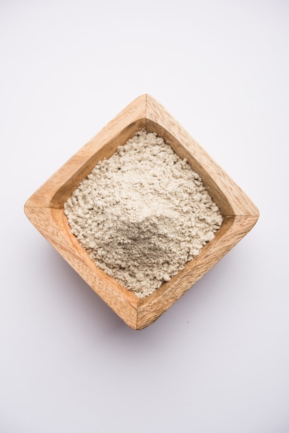 Bajra atta czyli mąka z prosa perłowego podawana w miseczce z małą drewnianą gałką, selektywne focus