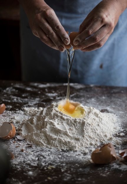 Baker rozbijania jaj do mieszaniny mąki