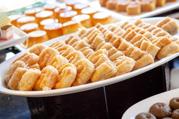 Baklava to warstwowy deser z ciasta filo wypełniony posiekanymi orzechami i słodzony syropem lub miodem Stół deserowy w tureckim hotelu