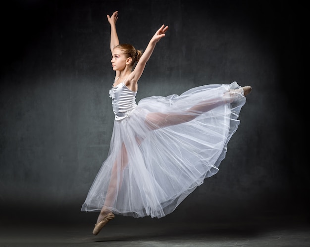 Balerina. śliczna Mała Dziewczynka Pozuje I Tanczy W Studiu. Dziewczyna Uczy Się Baletu.
