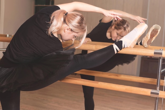 Zdjęcie balerina w czarnym stroju ćwiczy w studiu tańca