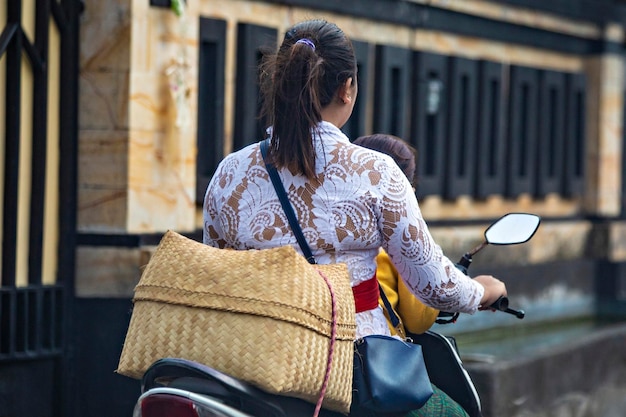 Balijska kobieta prowadząca motocykl na ulicy Bali, Indonezja