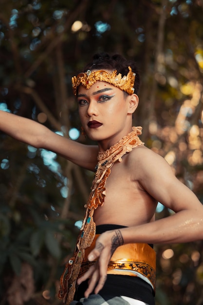 Balijski mężczyzna pozuje z jej ręką, mając na sobie złotą koronę i bez koszuli