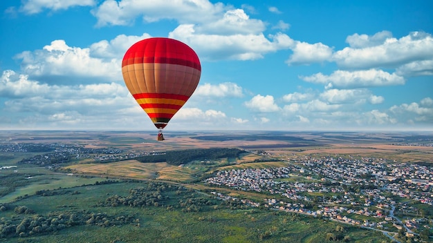 Balon lata nad ziemią na chmurowym niebie