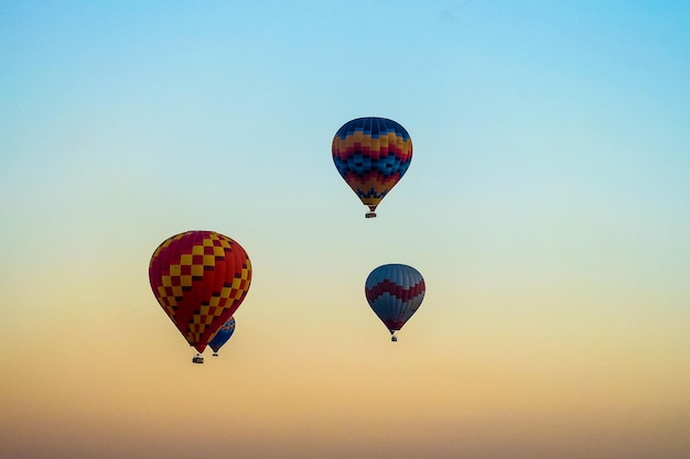 Balon na ogrzane powietrze lecący nad skalnym krajobrazem w Kapadocji, Turcja