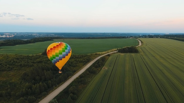 Balon na ogrzane powietrze na niebie nad polem