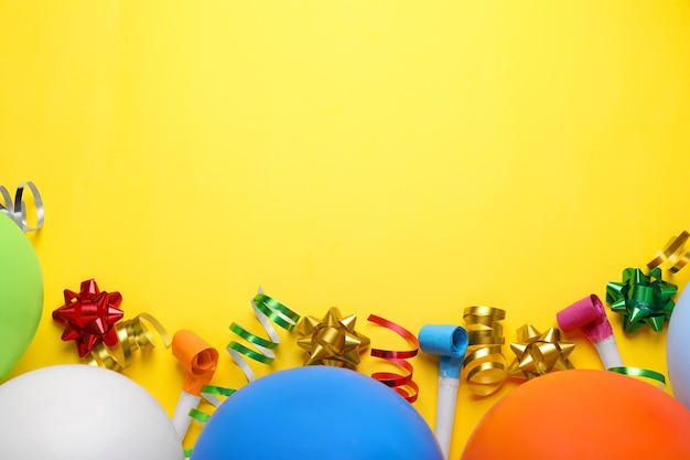 Balony, dmuchawy i serpentyny na przyjęcie urodzinowe na żółtym tle leżały płasko Miejsce na tekst