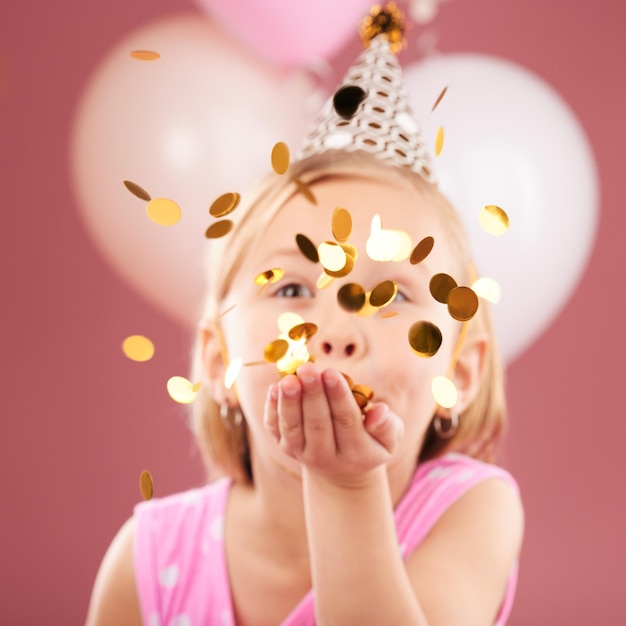 Balony urodziny i dziewczyna z konfetti na różowym tle na uroczystość imprezy i specjalny dzień Szczęśliwy podekscytowany i małe dziecko z dekoracją dla magicznego cudu i błyszczu na wydarzenie w studiu