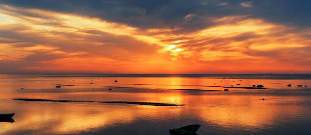 Bałtyk wczesnym rankiem złoty wschód słońca nad morzem Kutry rybackie na morzu na tle wschodu słońca i słońca Kurzeme Latvia