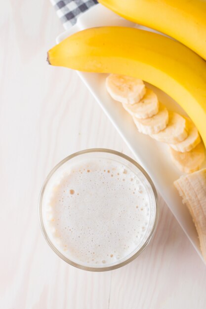 Zdjęcie bananowy smoothie na drewnianym stole.