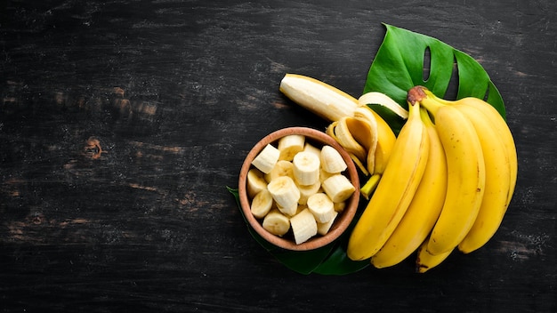 Banany na czarnej drewnianej powierzchni Owoce tropikalne Widok z góry Darmowe miejsce na kopię
