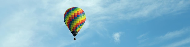 Baner 4x1 z latającym wielokolorowym balonem na tle błękitnego nieba z chmurami