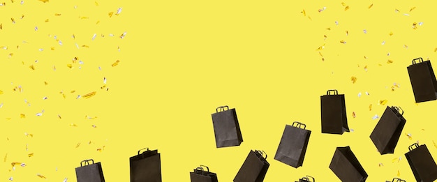 Zdjęcie baner z czarnymi torbami na zakupy wyprzedaży lata i błyszczy na żółtym tle z miejscem na kopię