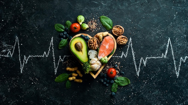 Zdjęcie baner żywności zdrowa żywność o niskiej zawartości węglowodanów jedzenie dla zdrowia serca łosoś awokado jagody brokuły orzechy i grzyby na czarnym kamiennym tle widok z góry