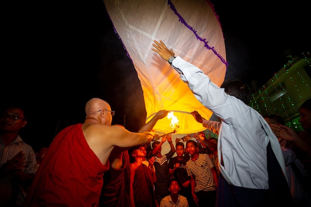 Zdjęcie bangladesz 13 października 2019 mnich buddyjski ze swoimi uczniami próbuje latać papierową latarnią w świątyni buddyjskiej ujani para w bandarban bangladesz