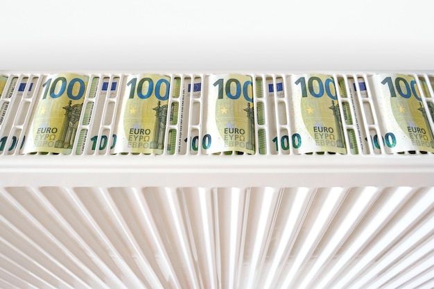 Banknoty euro na grzejniku domowym Kryzys energetyczny i drogie koszty ogrzewania w sezonie zimowym